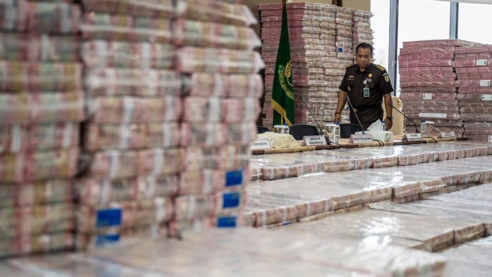 Petugas merapikan barang bukti uang sitaan dalam konfrensi pers kasus korupsi ekspor crude plam oil (CPO) di gedung bundar jampidsus kejaksaan agung